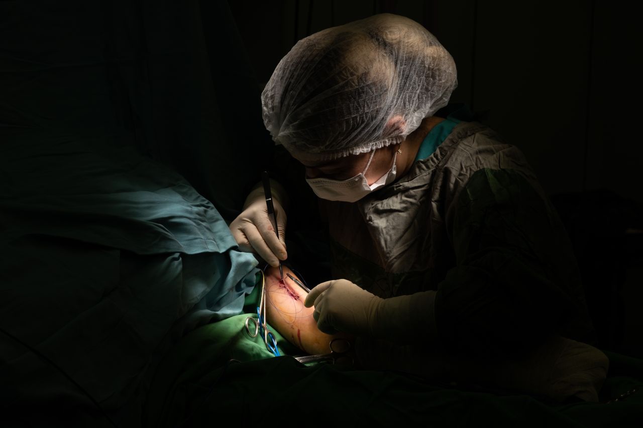 Mastering the First Impression: Your intriguing post title goes here Close-up of a surgeon performing a procedure under focused light in an operating room.