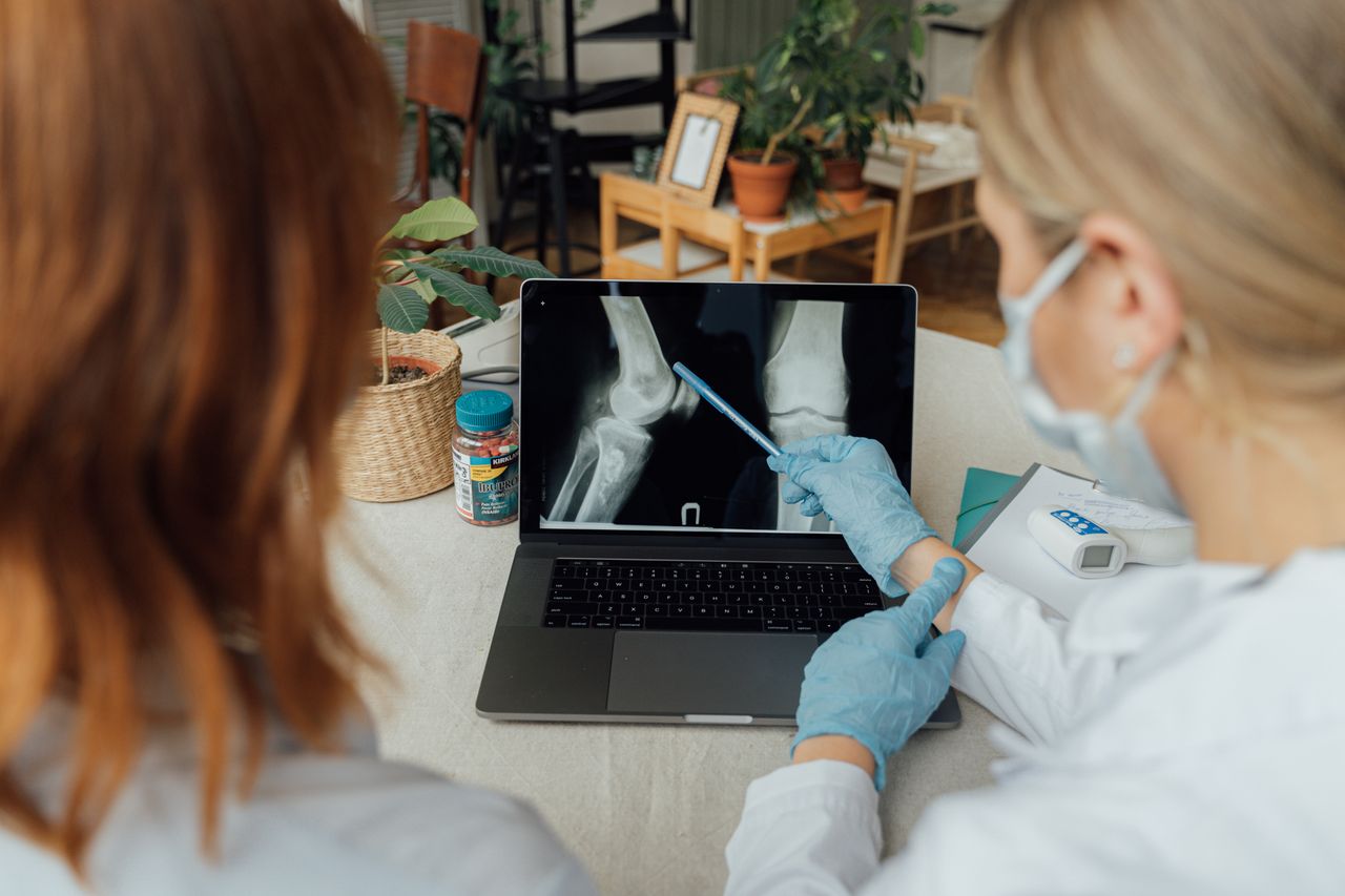 Crafting Captivating Headlines: Your awesome post title goes here Two healthcare workers in a consultation reviewing x-ray images on a laptop.